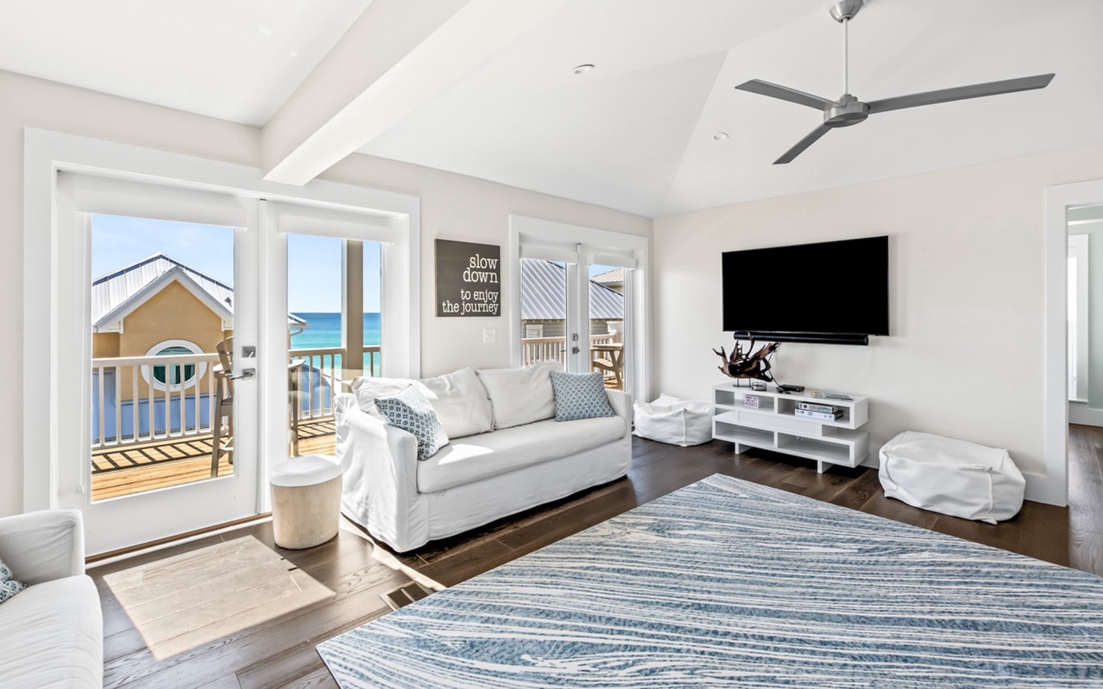 Unwind in your bright living space where ocean breezes flow through French doors and coastal comfort meets modern style.