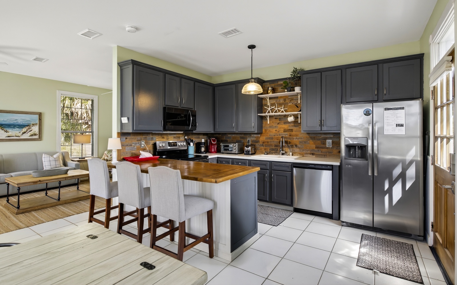 Your spacious kitchen features sleek navy cabinets, gleaming stainless appliances, and a warm brick backsplash, perfect for cooking memorable meals together.