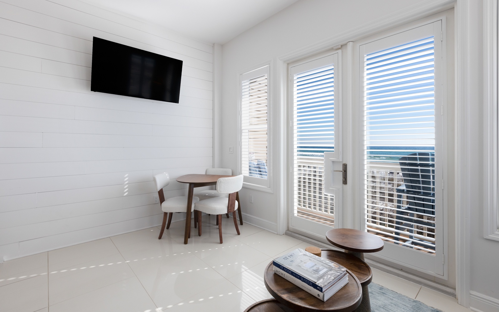 Bright coastal living space with sea views through French doors and your own dining table for morning coffee.