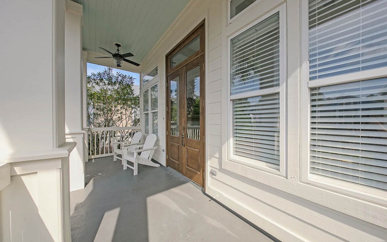 Your private covered porch invites peaceful moments with comfortable seating and gentle breezes from the ceiling fan overhead.