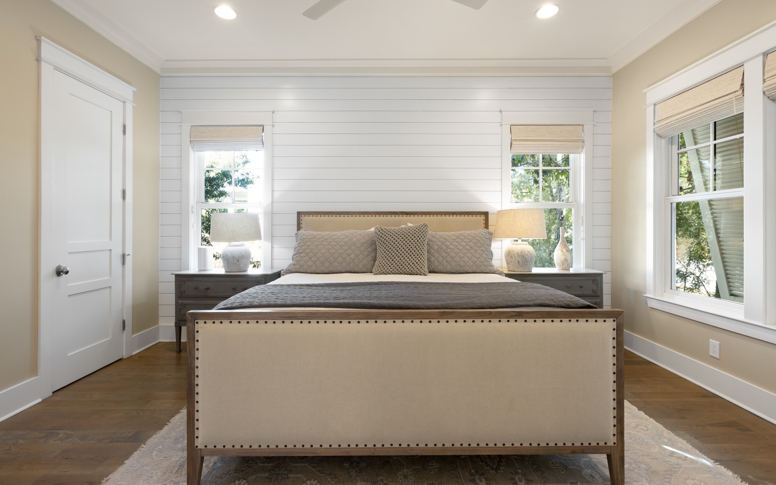 Sink into this elegant bedroom's plush bedding after your day exploring, with natural light streaming through stylish windows.