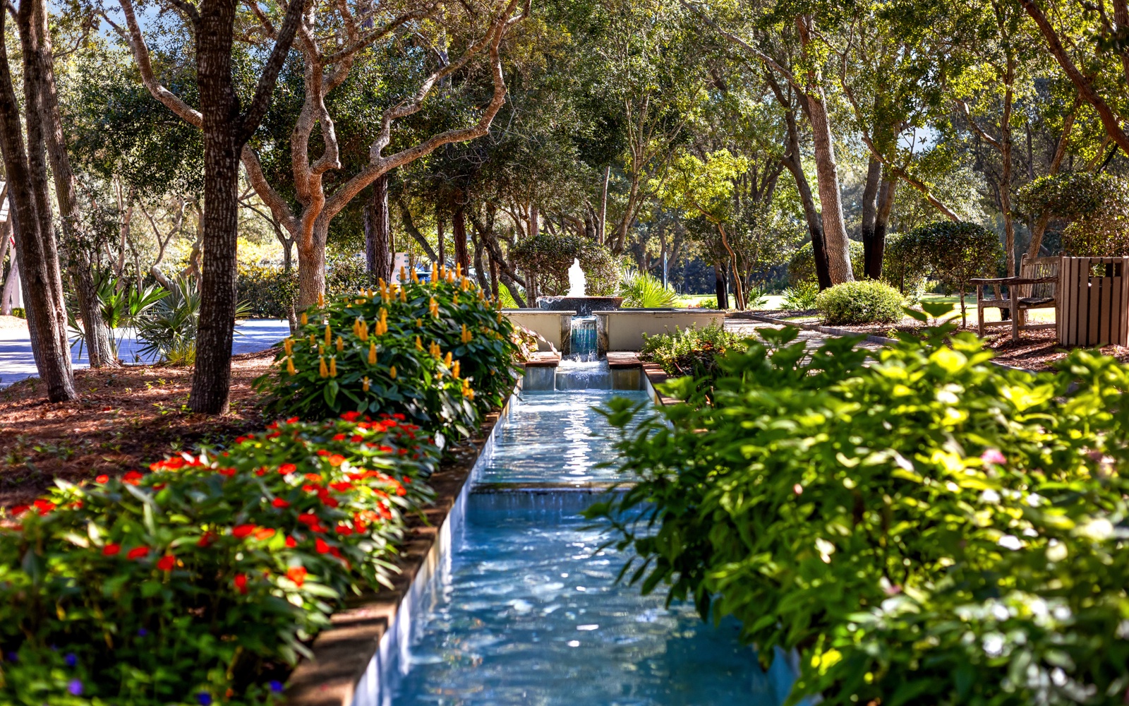 Peaceful water feature winds through lush landscaping, creating a serene garden oasis perfect for quiet moments.