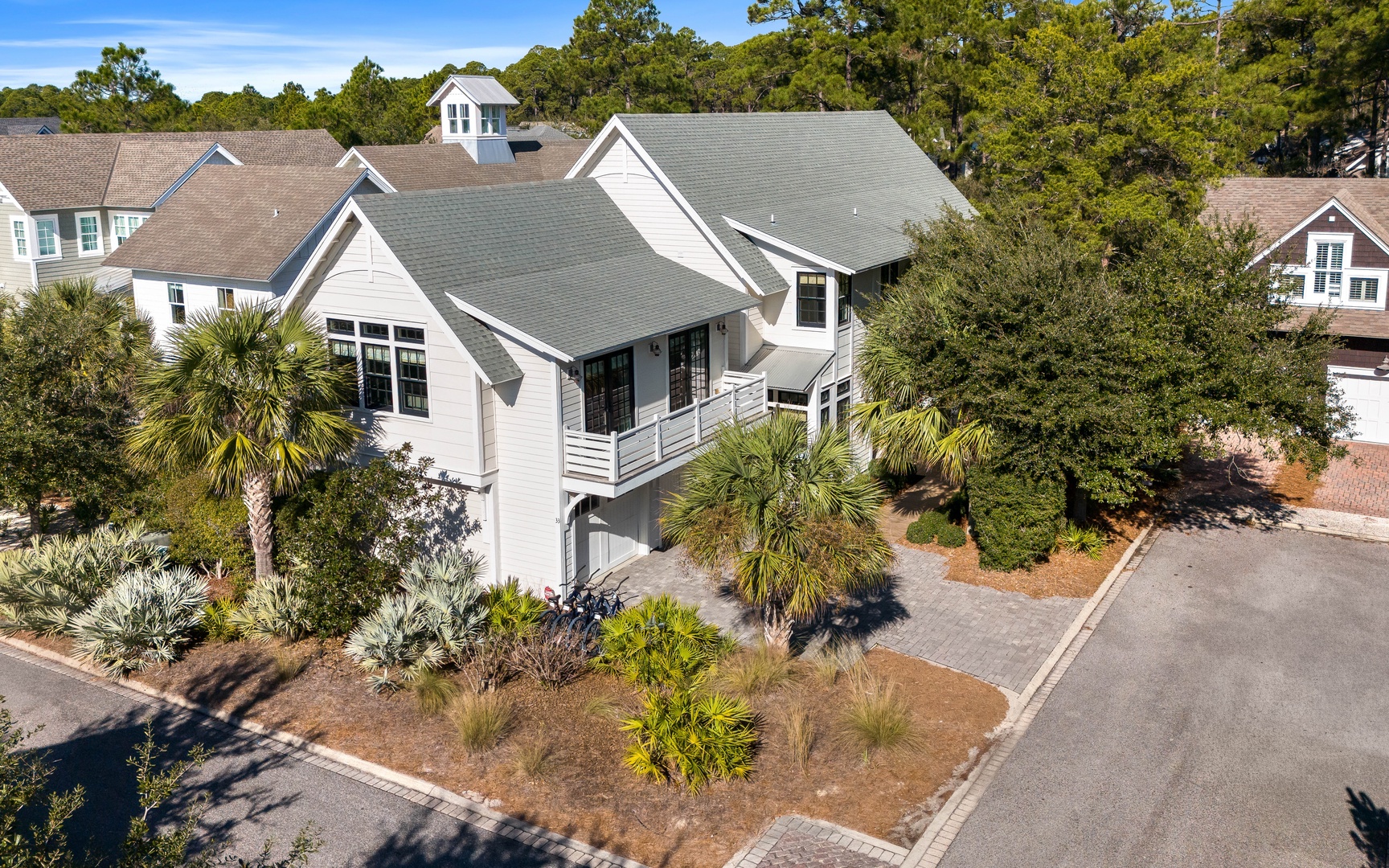 Coastal contemporary home nestled in mature trees with tropical landscaping and convenient street access.