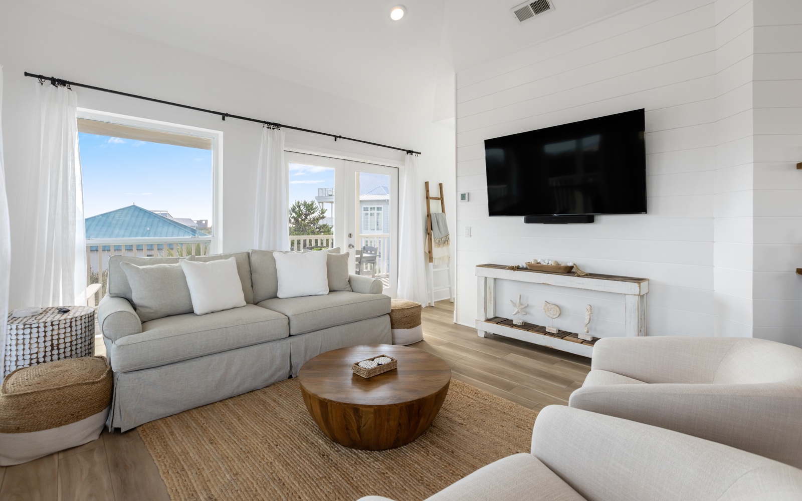 Sink into plush seating while natural light fills your coastal retreat, complete with entertainment and serene views.