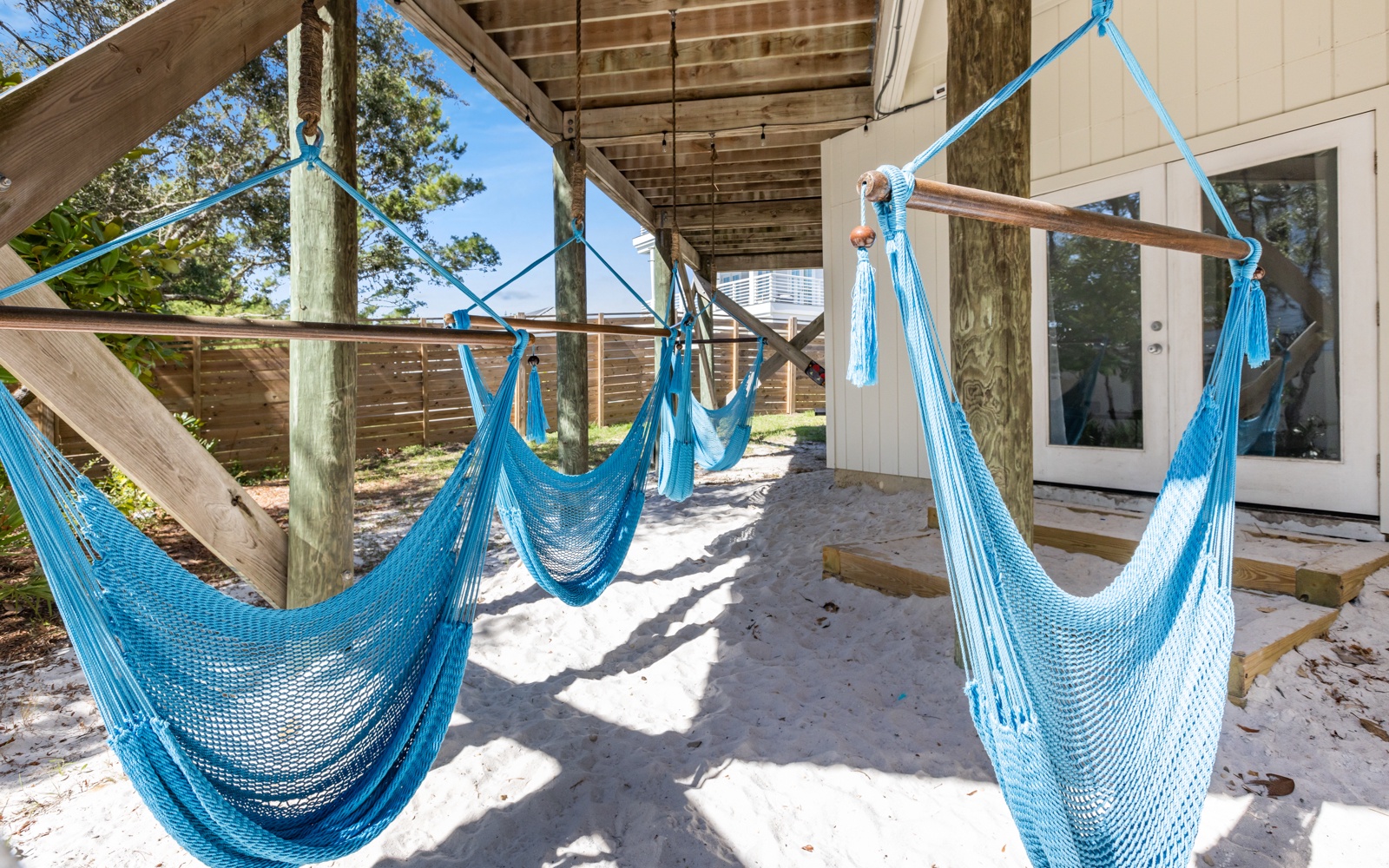 Sway gently in turquoise hammocks on your covered porch, where coastal breezes and dappled sunlight create your perfect afternoon escape.