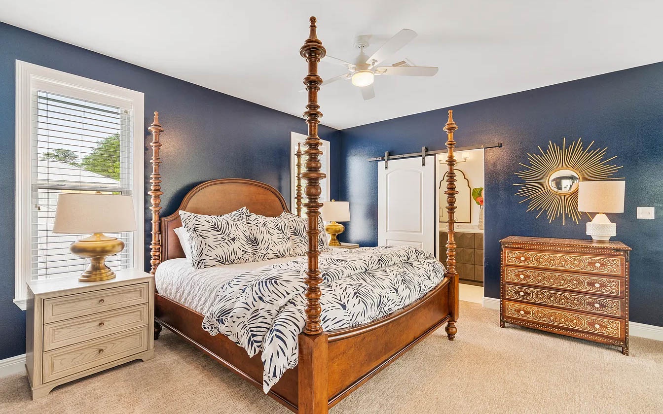 Unwind in your elegant bedroom featuring a stunning four-poster bed, rich navy walls, and thoughtful decor that creates the perfect sanctuary for restful nights.
