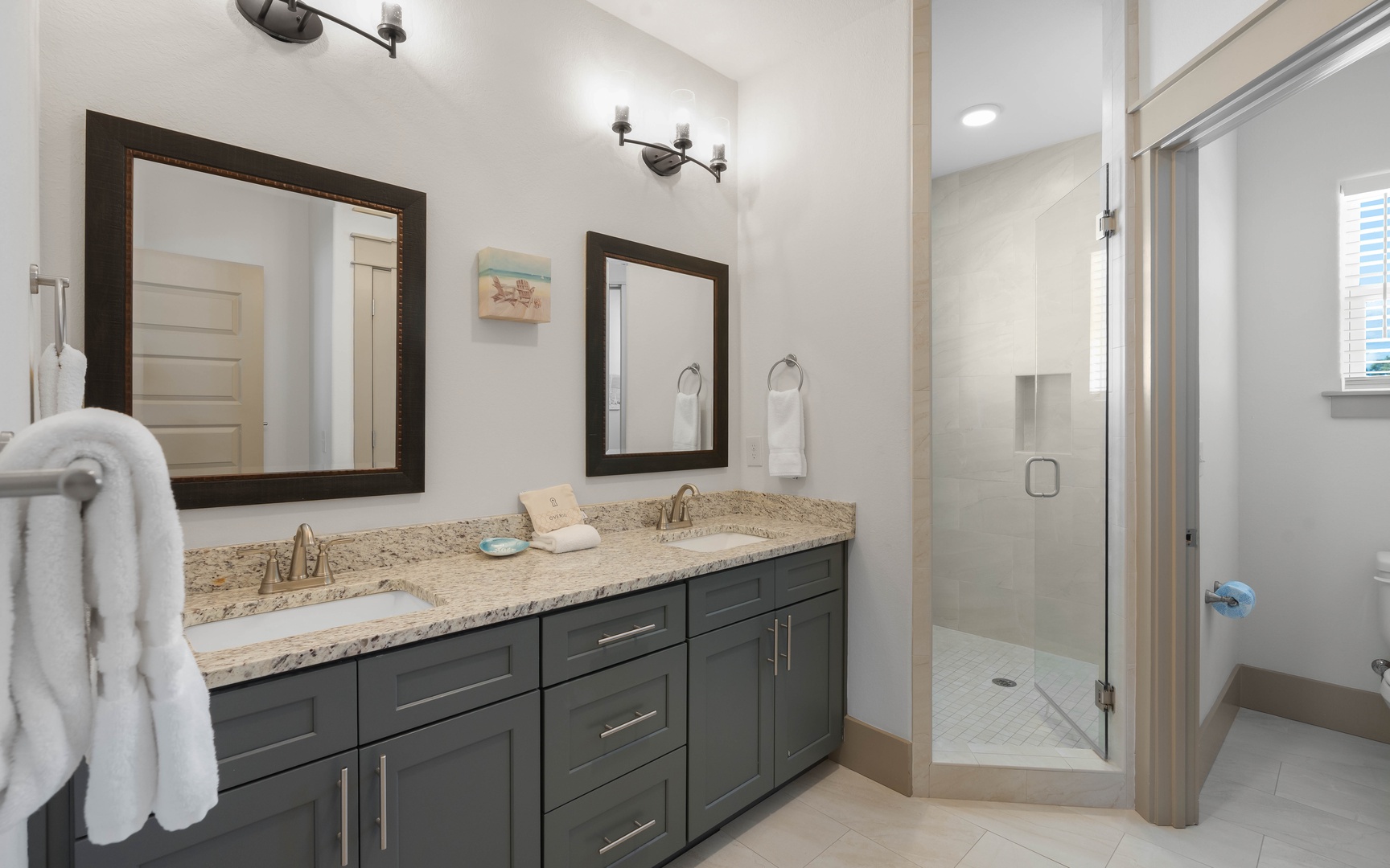 Your private spa-like bathroom features dual vanities with granite countertops, elegant fixtures, and a spacious walk-in shower for ultimate relaxation.