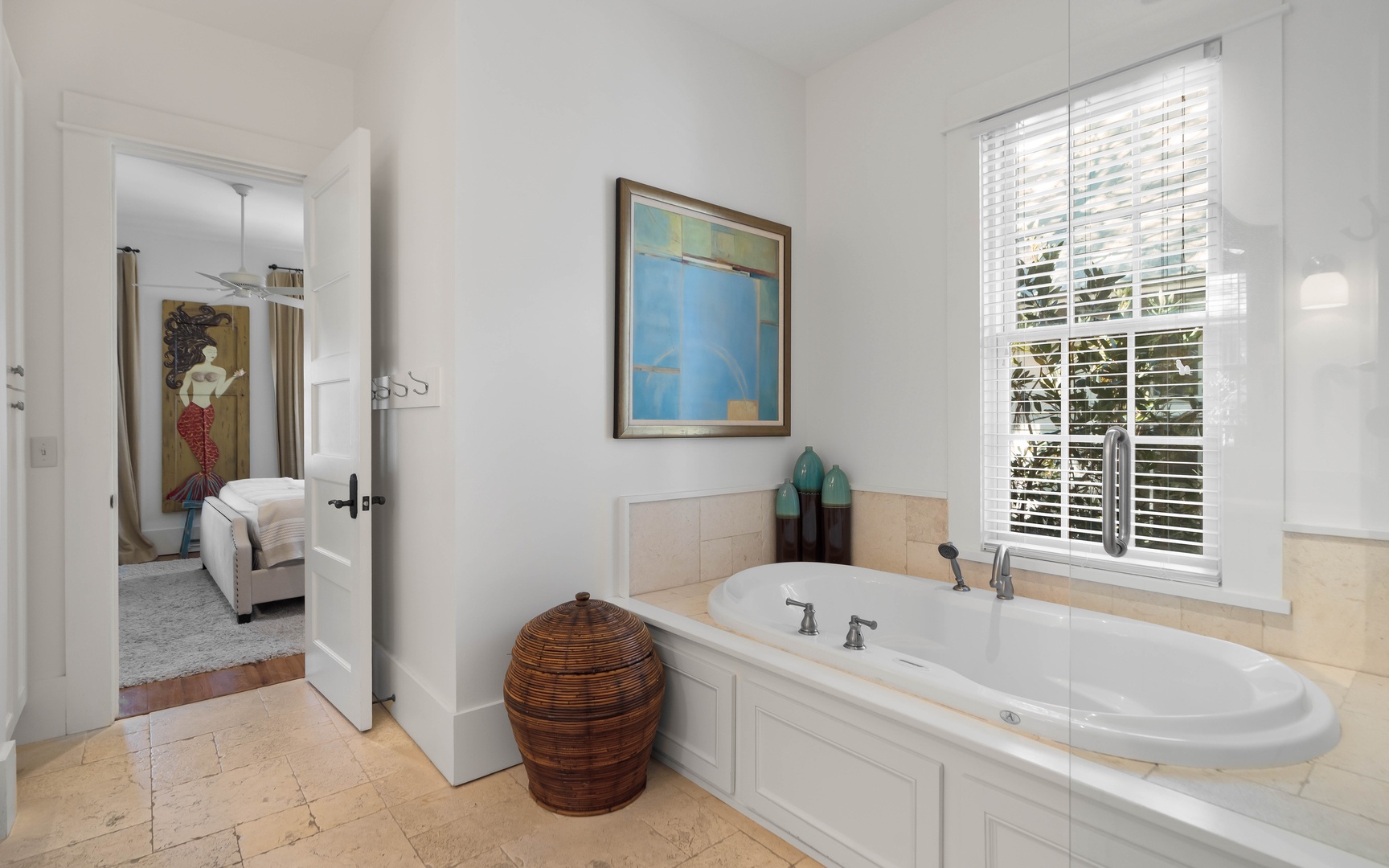 Unwind in your private spa-like bathroom, featuring a luxurious soaking tub perfectly positioned by the window for natural light and tranquil garden views.