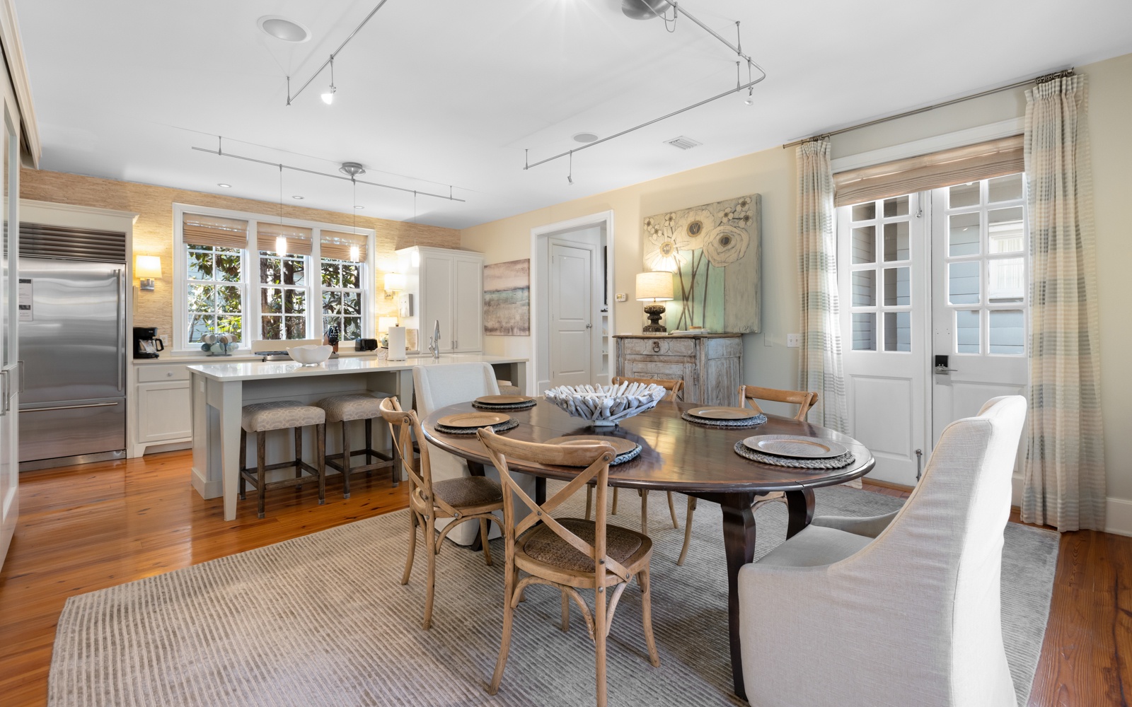 Gather around this elegant dining table where warm hardwood floors and natural light create the perfect setting for your memorable meals together.