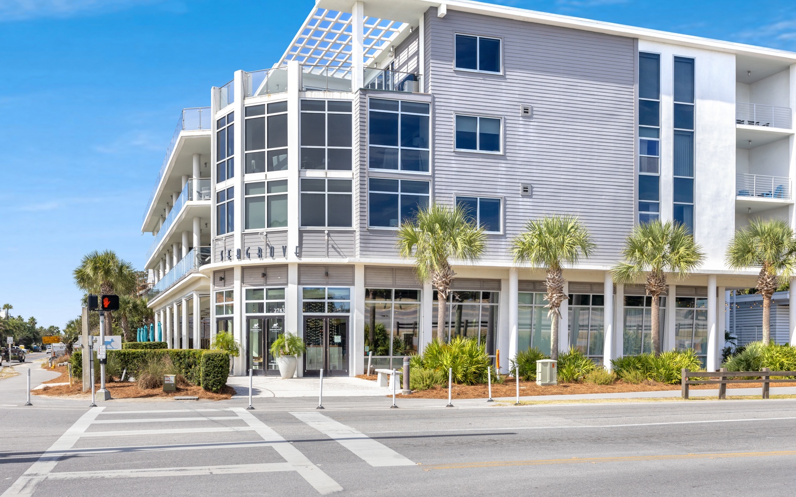 Modern beachside building with contemporary architecture and palm-lined streetscape in a vibrant coastal neighborhood.
