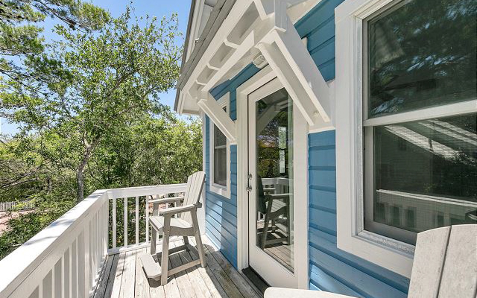 Step onto your private balcony where morning coffee tastes better with tree-lined views and gentle breezes through charming coastal architecture.