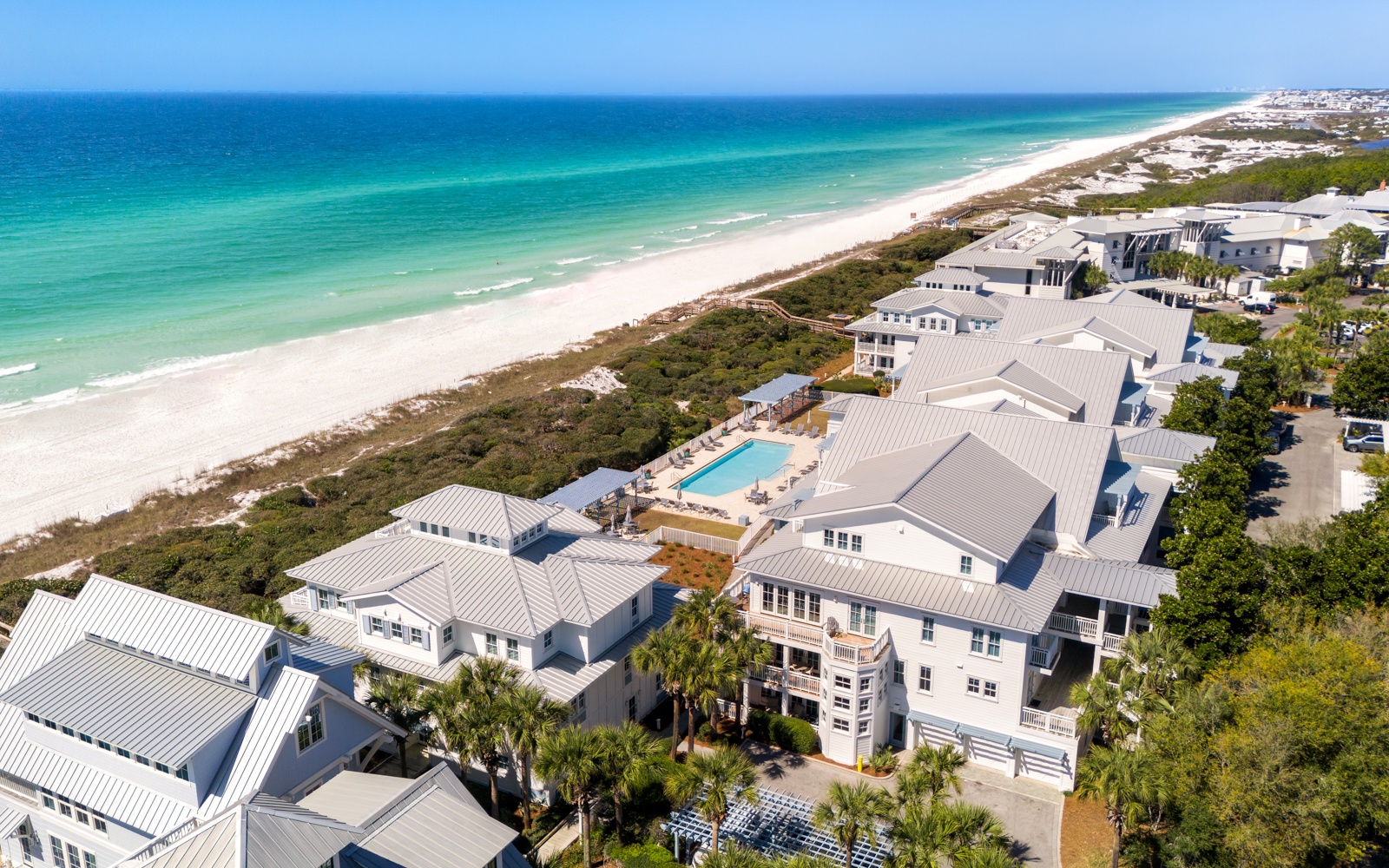 Stunning beachfront resort complex with pristine white sand beaches and turquoise waters just steps away from elegant accommodations.