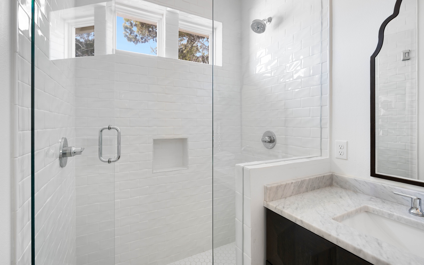 Bright, spa-like bathroom with walk-in shower and marble vanity awaits your daily refresh.