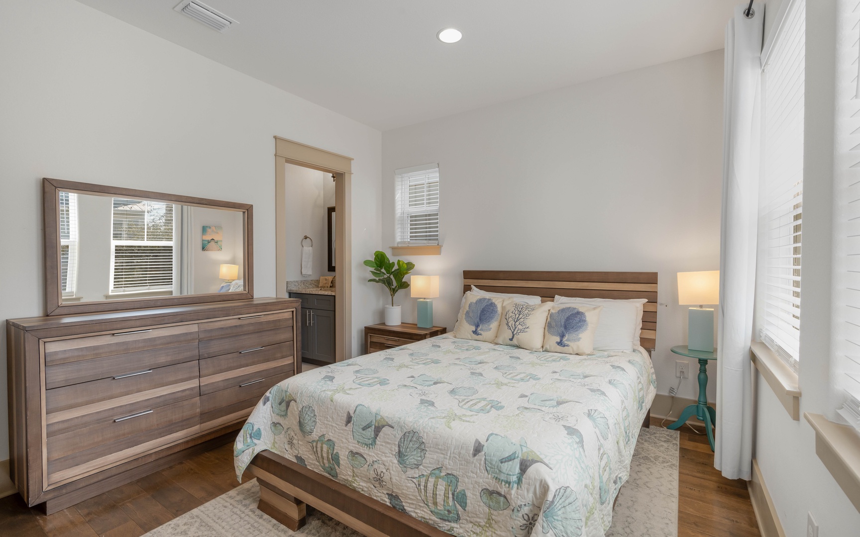 Relax in your peaceful bedroom with modern wood furnishings, soft linens, and calming coastal decor that creates the perfect retreat.