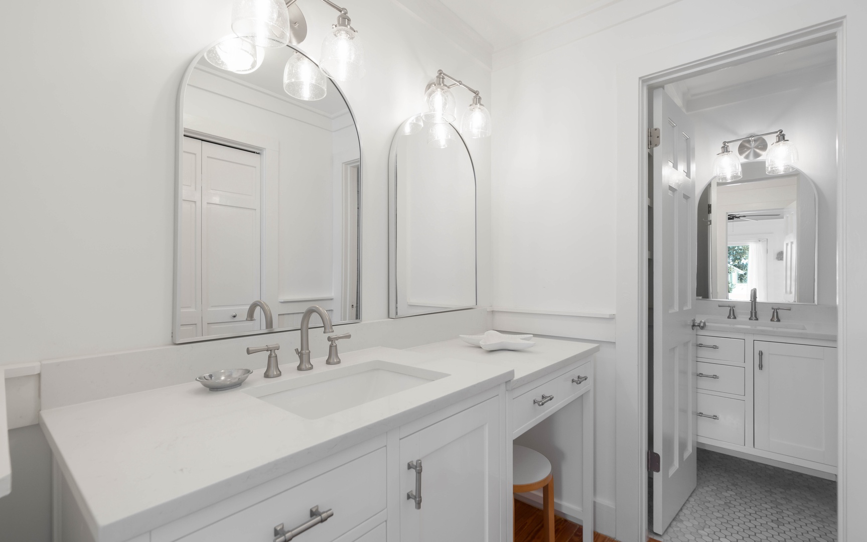 Pamper yourself in this pristine bathroom with elegant dual vanities, perfect lighting, and luxurious marble countertops for your morning routine.