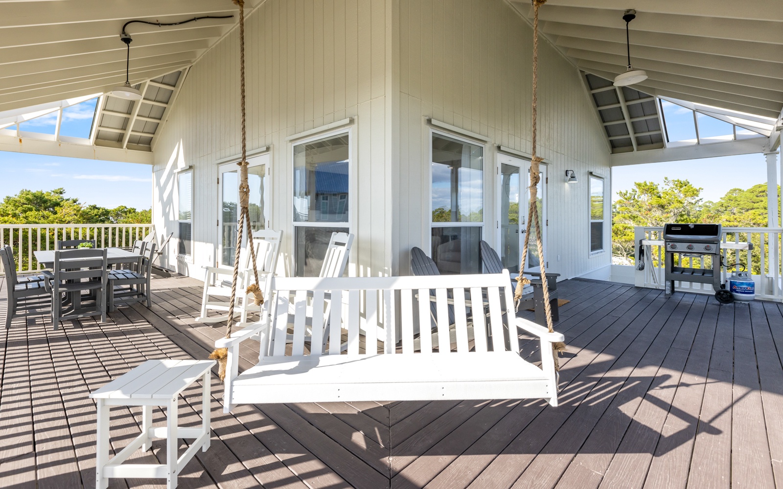 Relax on your private deck with a charming porch swing and BBQ grill, perfect for peaceful moments.
