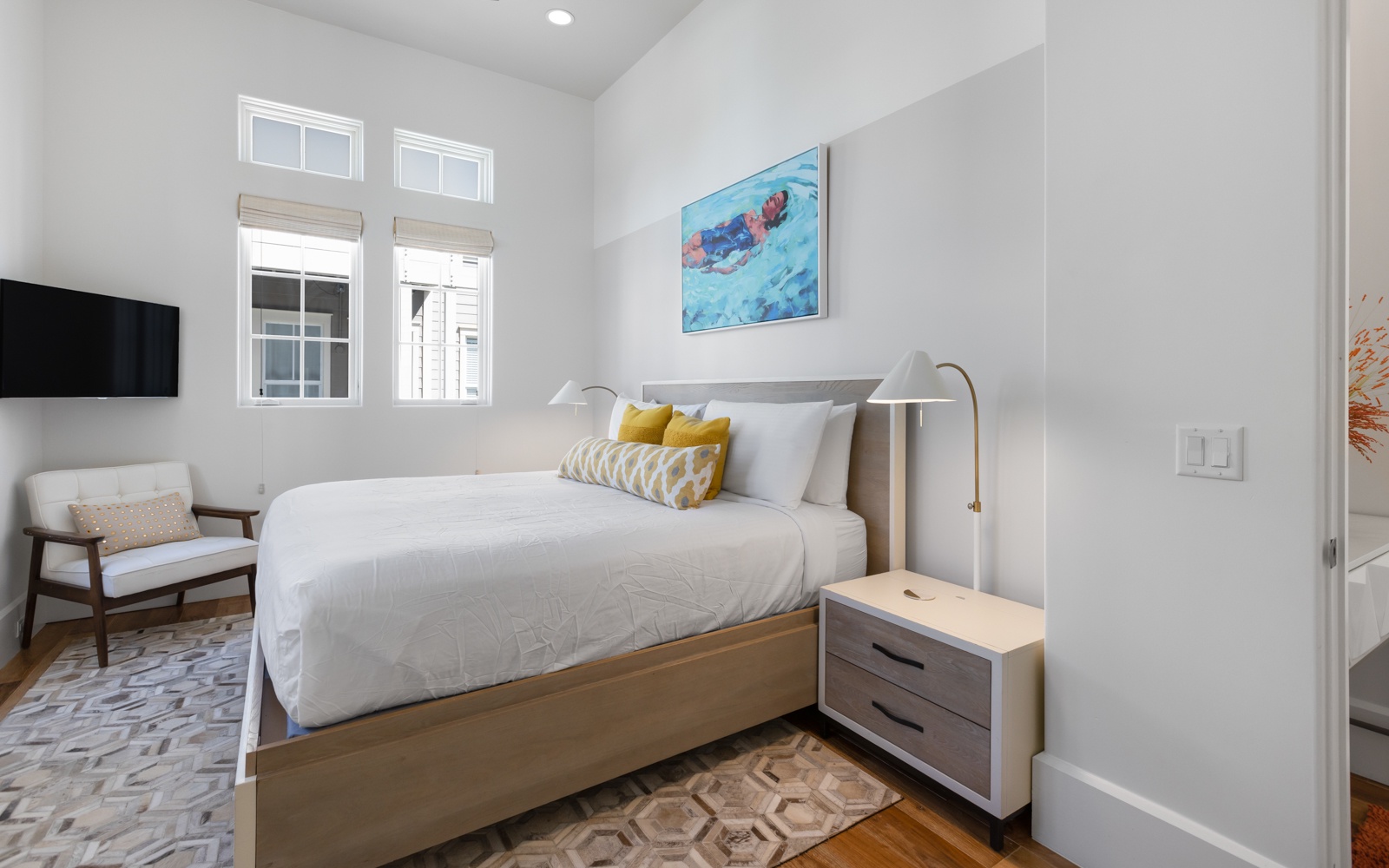 Sink into crisp linens and enjoy morning light streaming through your windows in this stylish bedroom retreat.