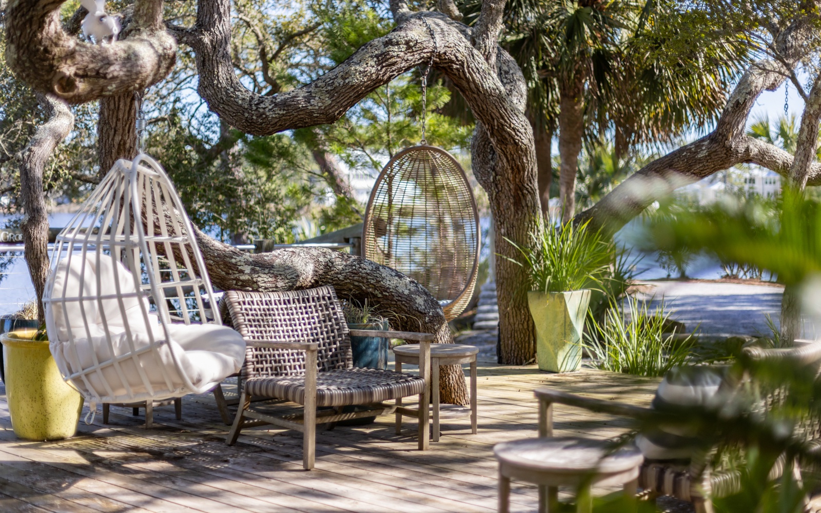 Unwind in your private tropical sanctuary with cozy wicker chairs beneath swaying palms, where ocean breezes and dappled sunlight create the perfect escape.