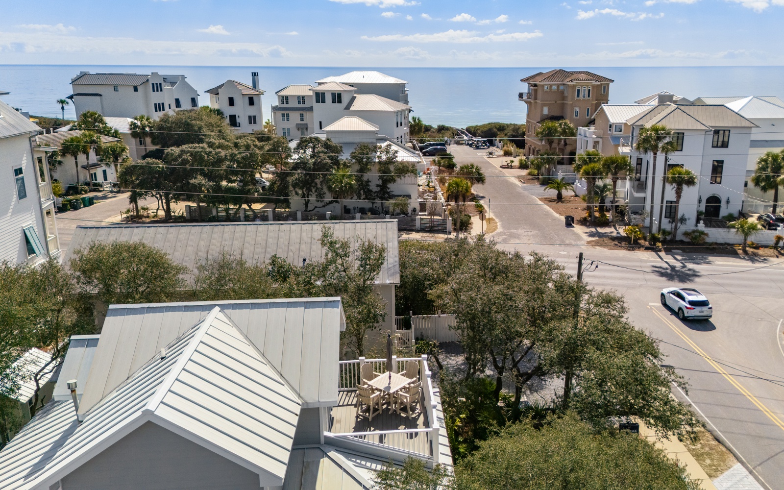 Coastal community with beachside homes and tree-lined streets leading to the waterfront.