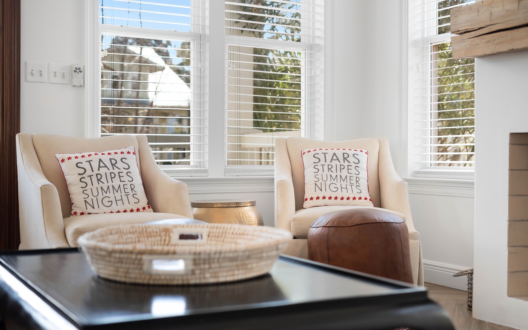 Sink into these cozy chairs by bright windows, where patriotic pillows and warm light create your perfect reading nook.