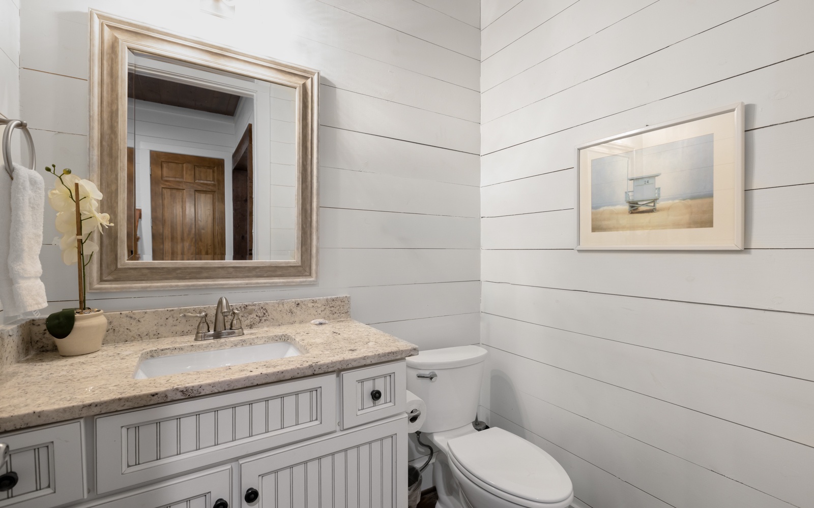 You'll love this bright bathroom with its coastal charm and granite counters for your morning routine.