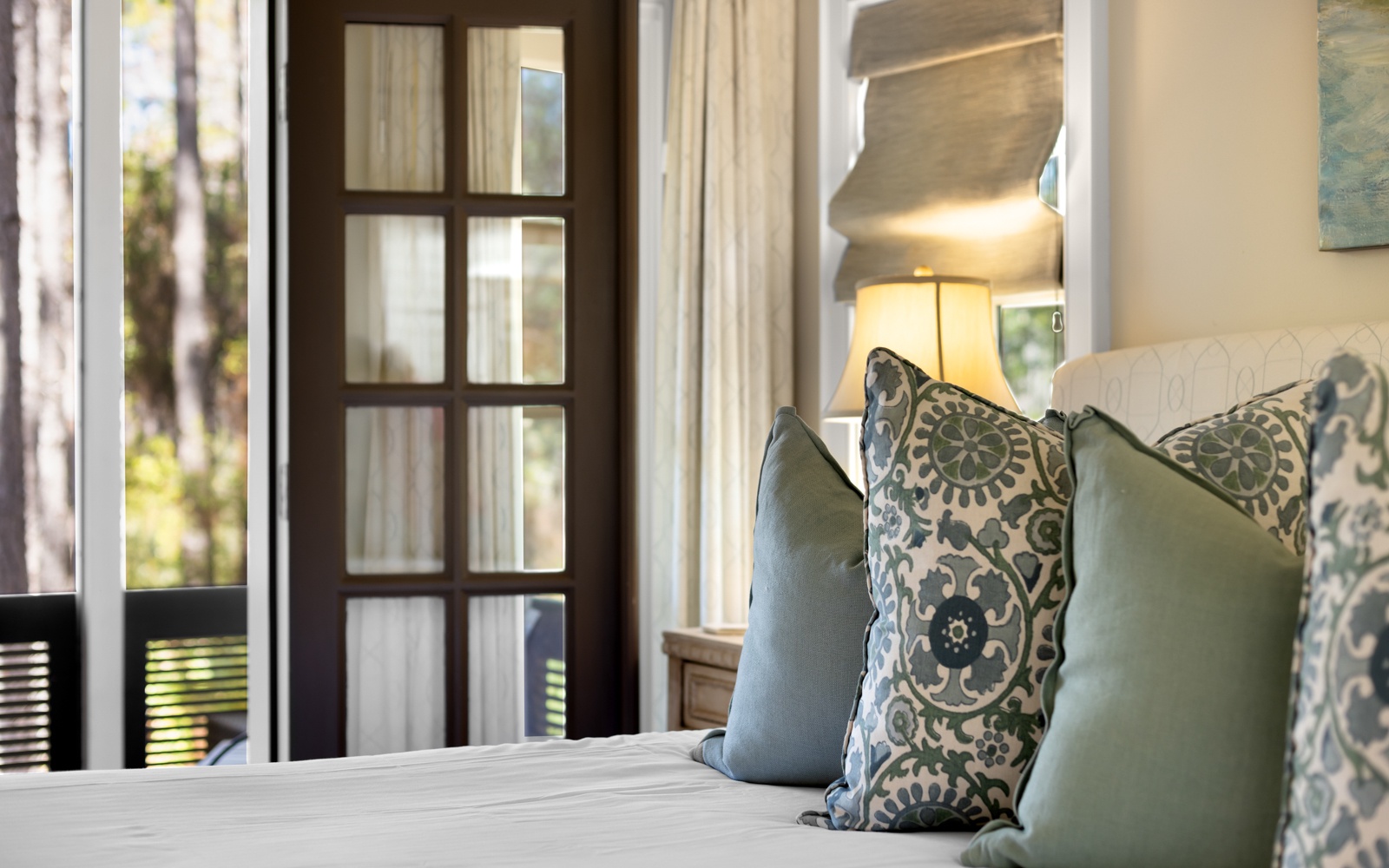 Sink into plush pillows where morning light dances through elegant French doors, creating your perfect sanctuary for rest and relaxation.