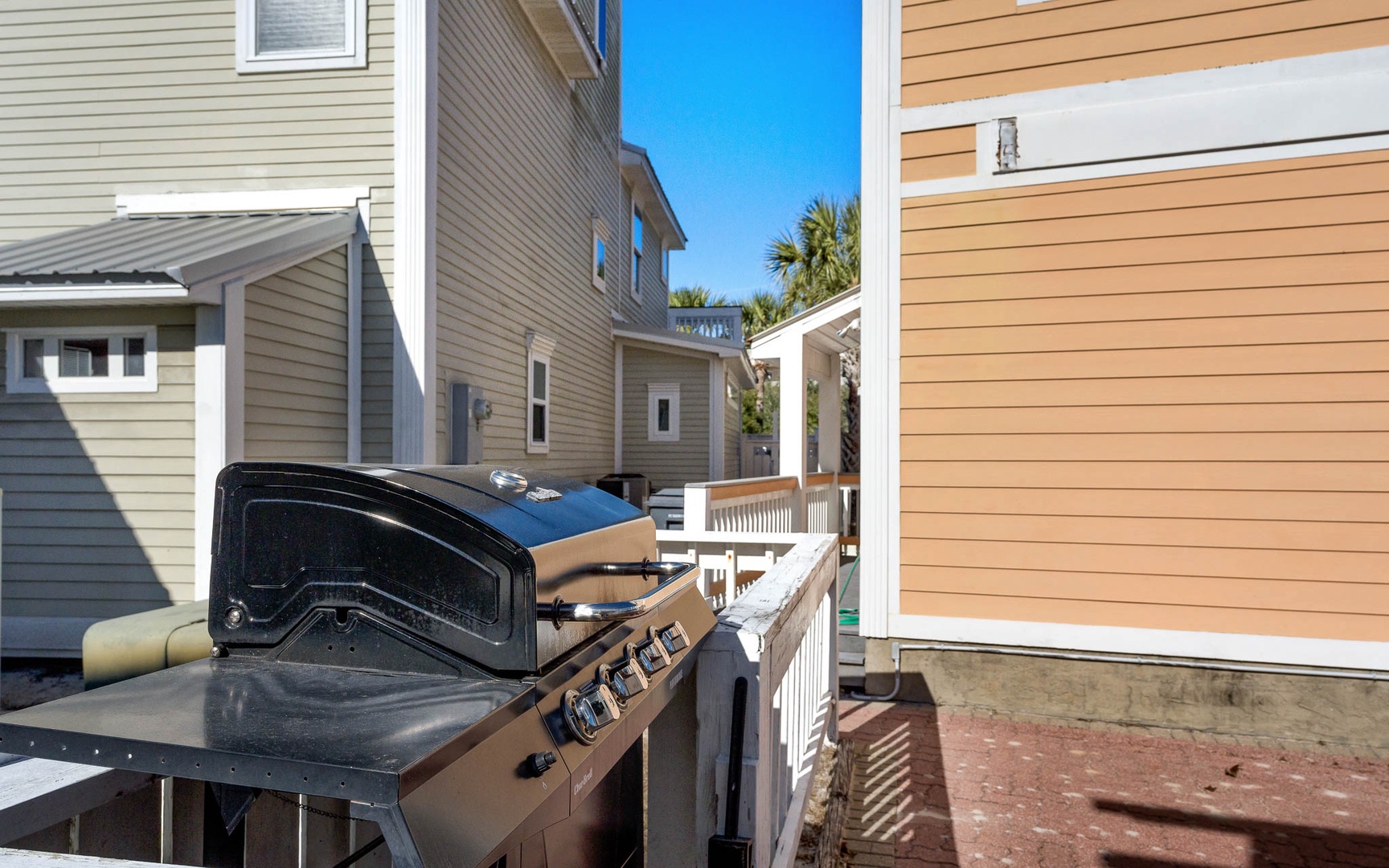 Fire up the grill on your private deck and savor outdoor cooking with neighboring homes and palm trees creating a cozy coastal community feel.