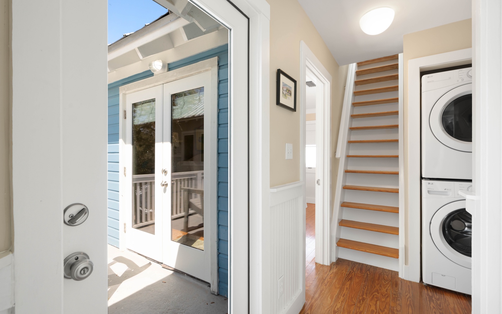 Step into your bright entryway featuring convenient laundry facilities and elegant wooden stairs leading to your upstairs retreat.