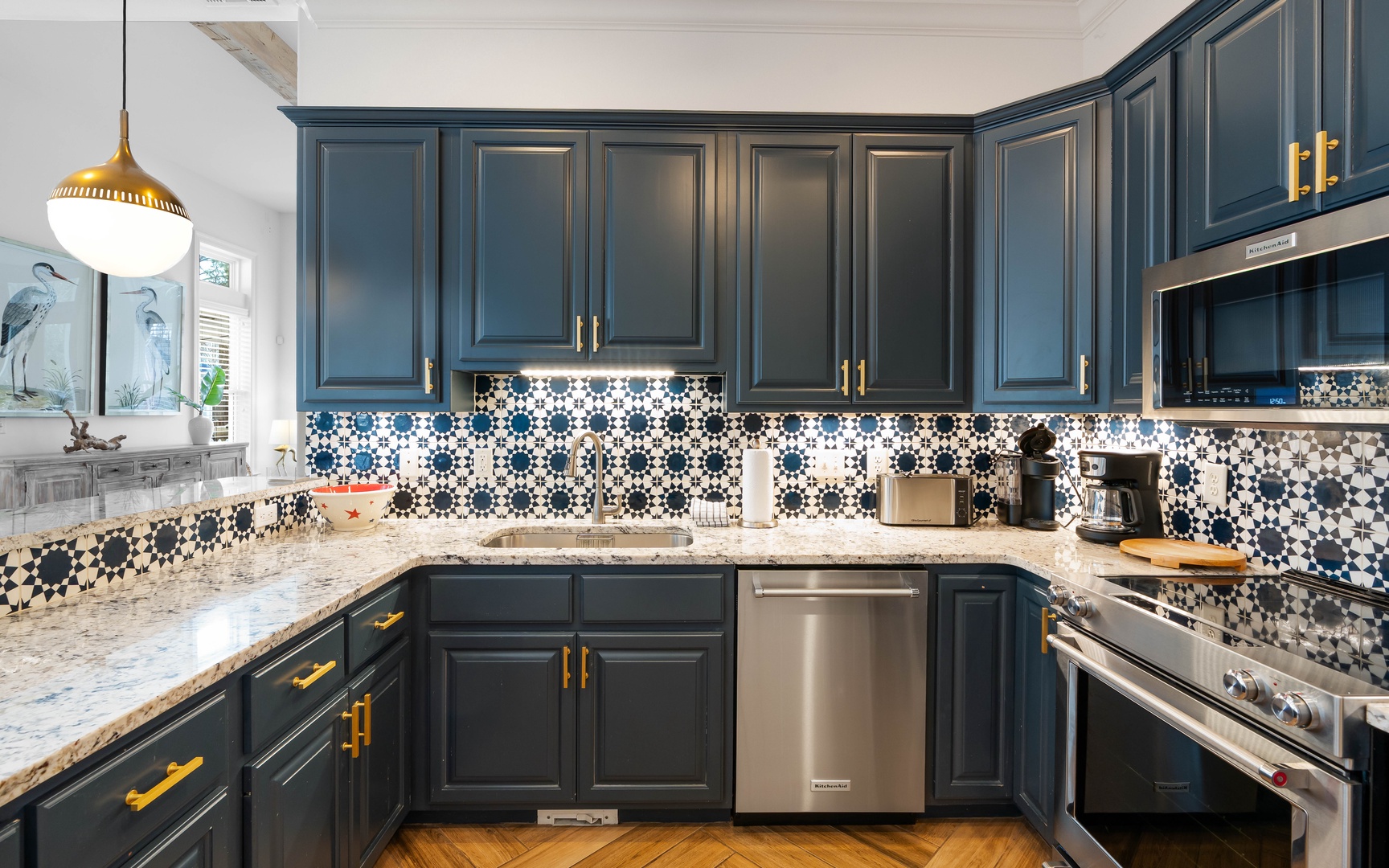 Cook your favorite meals in this stunning kitchen with bold navy cabinets, striking tile backsplash, and premium stainless appliances.