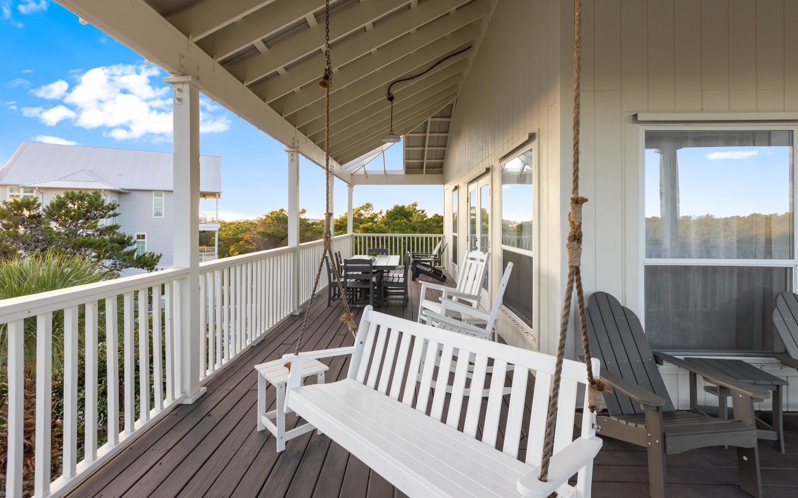 Relax on your private covered deck with coastal views, swing seating, and dining space for memorable evenings.