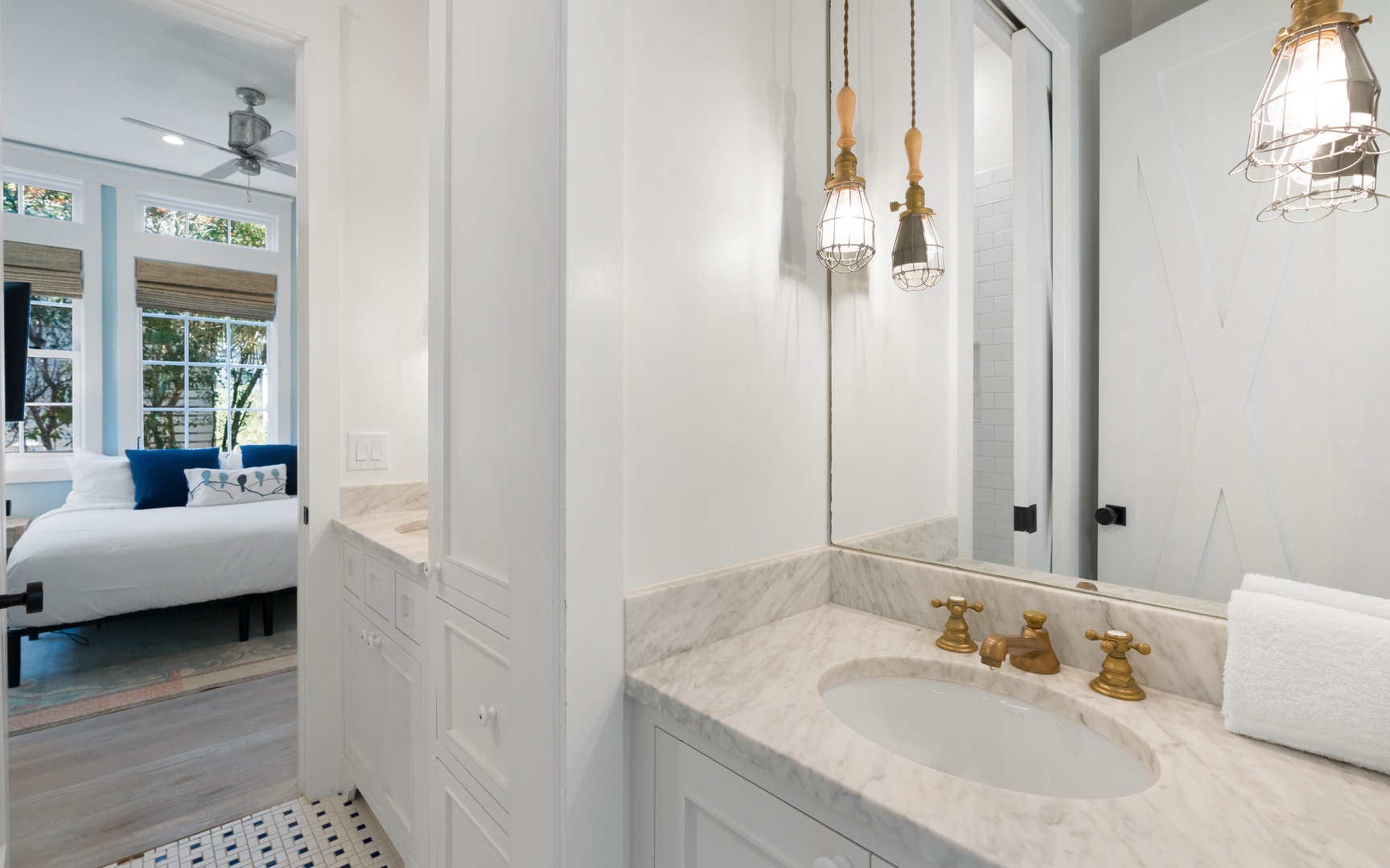 Unwind in your marble-appointed bathroom with elegant brass fixtures, where industrial pendant lighting creates a spa-like ambiance.