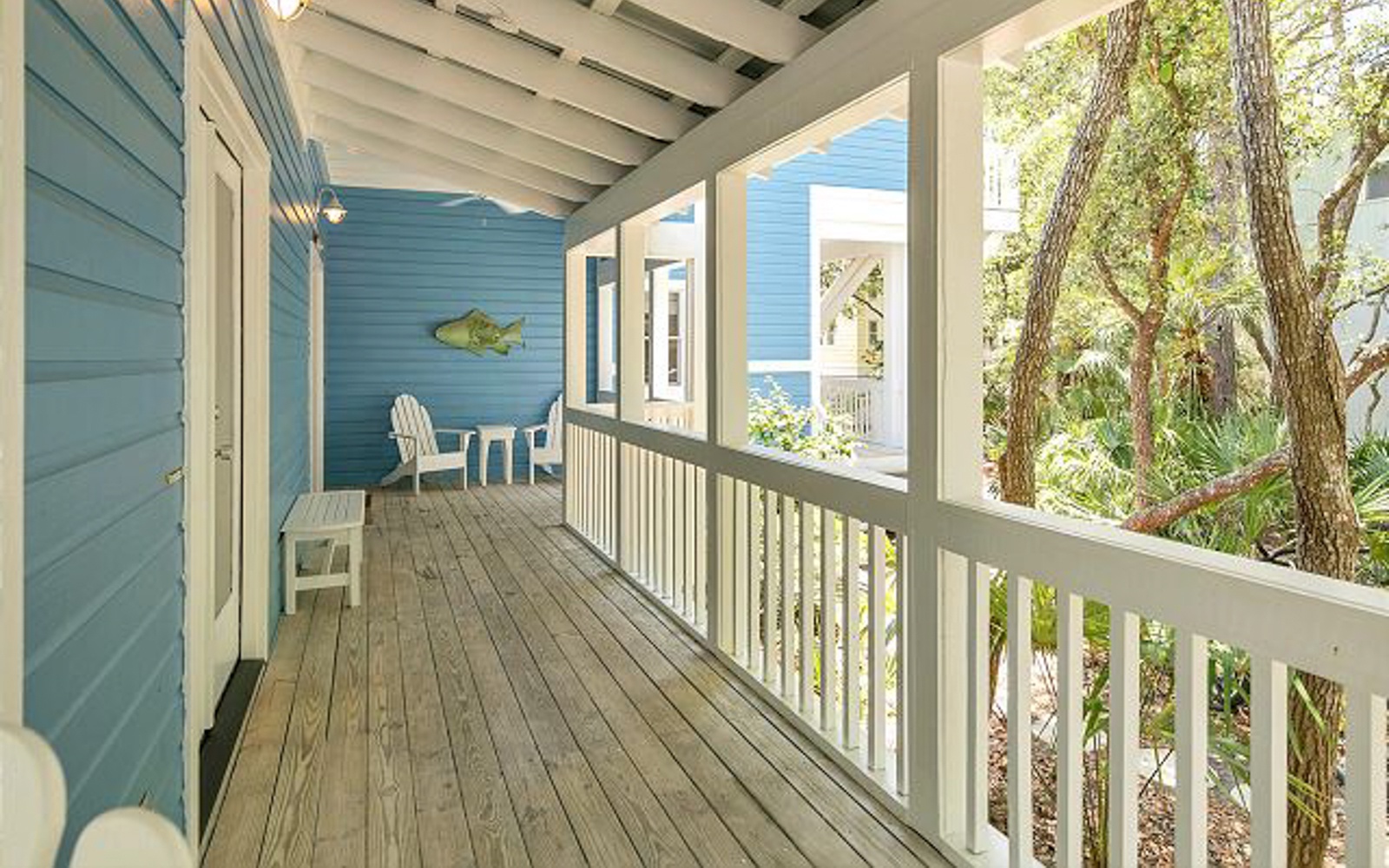 Relax on your private covered balcony with charming seating and peaceful garden views through mature trees.