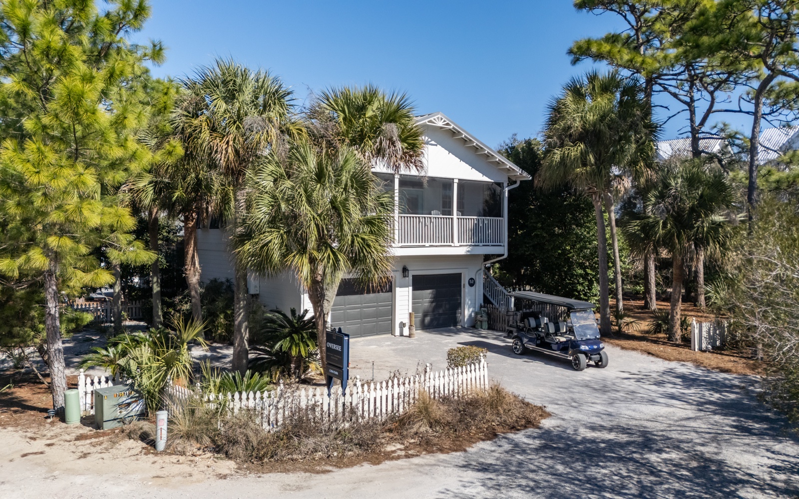 Charming coastal retreat nestled among towering palms with convenient garage parking and screened porch for relaxing island evenings.