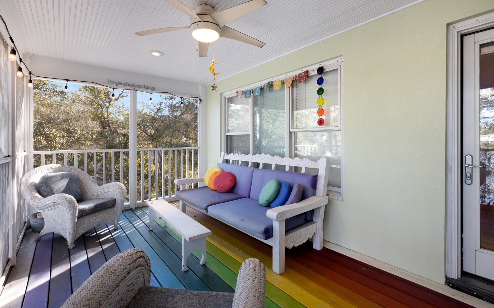 Relax on your private screened porch with colorful rainbow floors and cozy seating overlooking peaceful treetops.