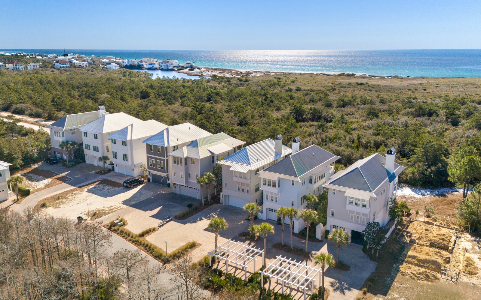 Stunning community featuring modern coastal homes nestled between pristine shoreline and lush natural preserve, offering an exclusive seaside escape.