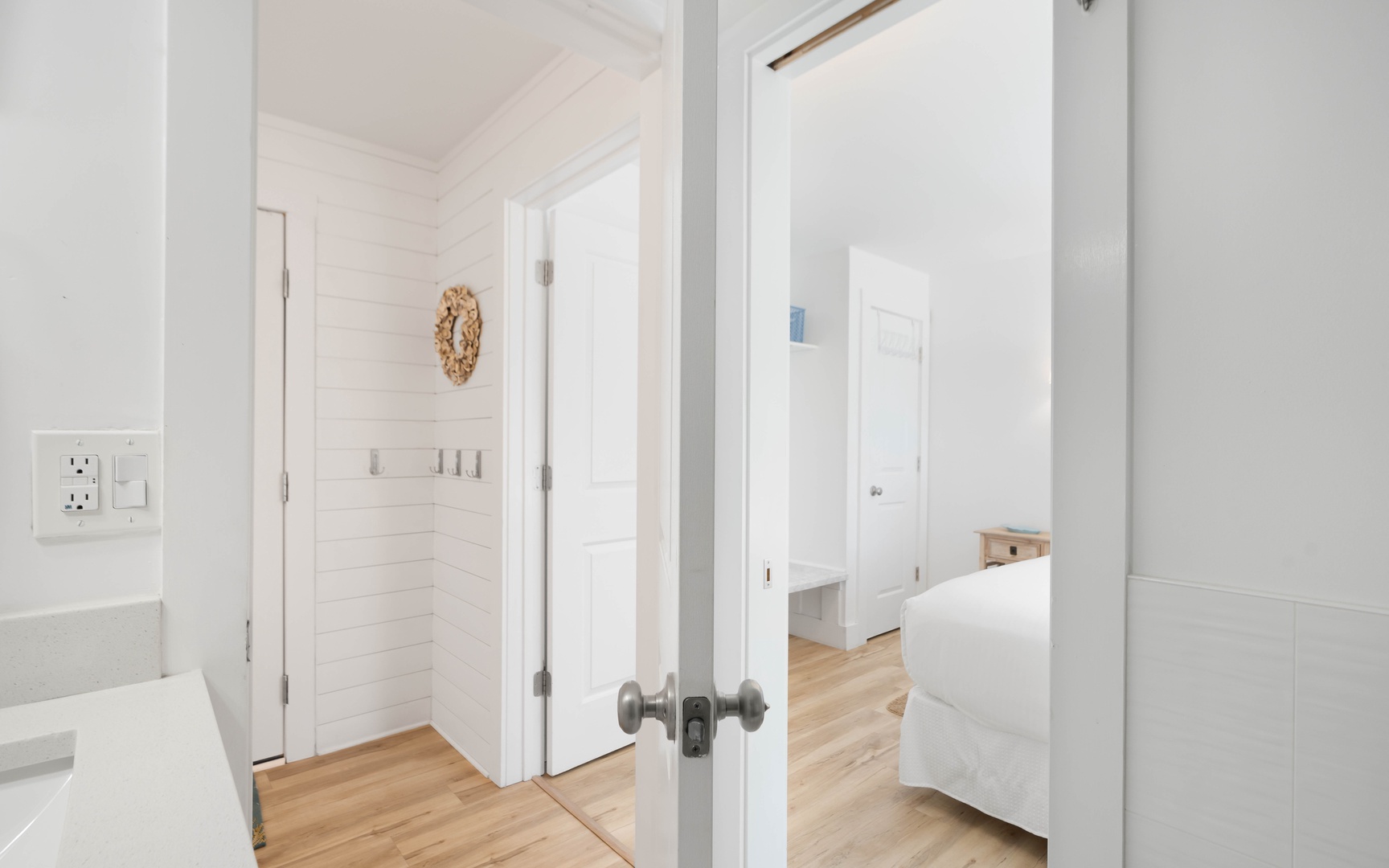 Step into your bright, airy retreat where crisp white walls and warm hardwood floors create a serene sanctuary for your coastal getaway.