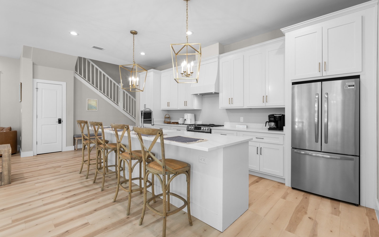 Step into your bright, modern kitchen where gleaming white cabinets and elegant pendant lighting create the perfect space for morning coffee and memorable meals together.