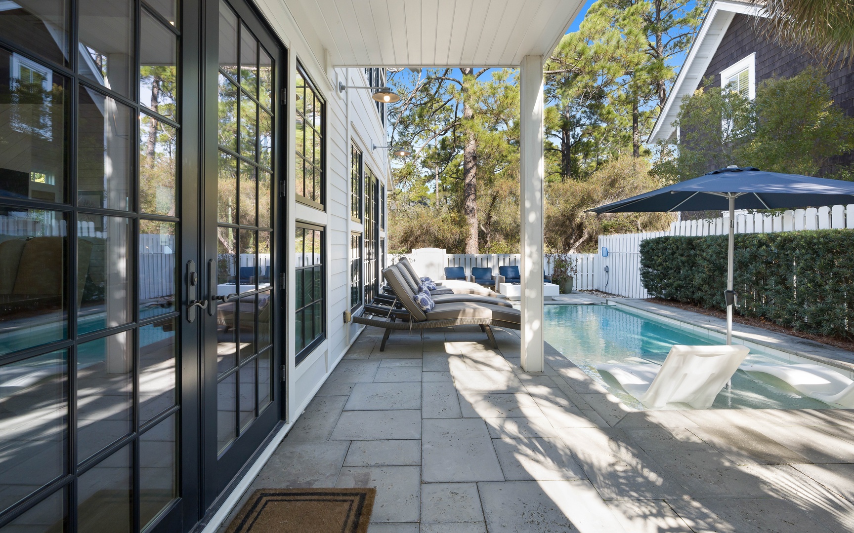 Step onto your private covered terrace where comfortable lounge chairs await beside your sparkling pool, perfect for afternoon relaxation.