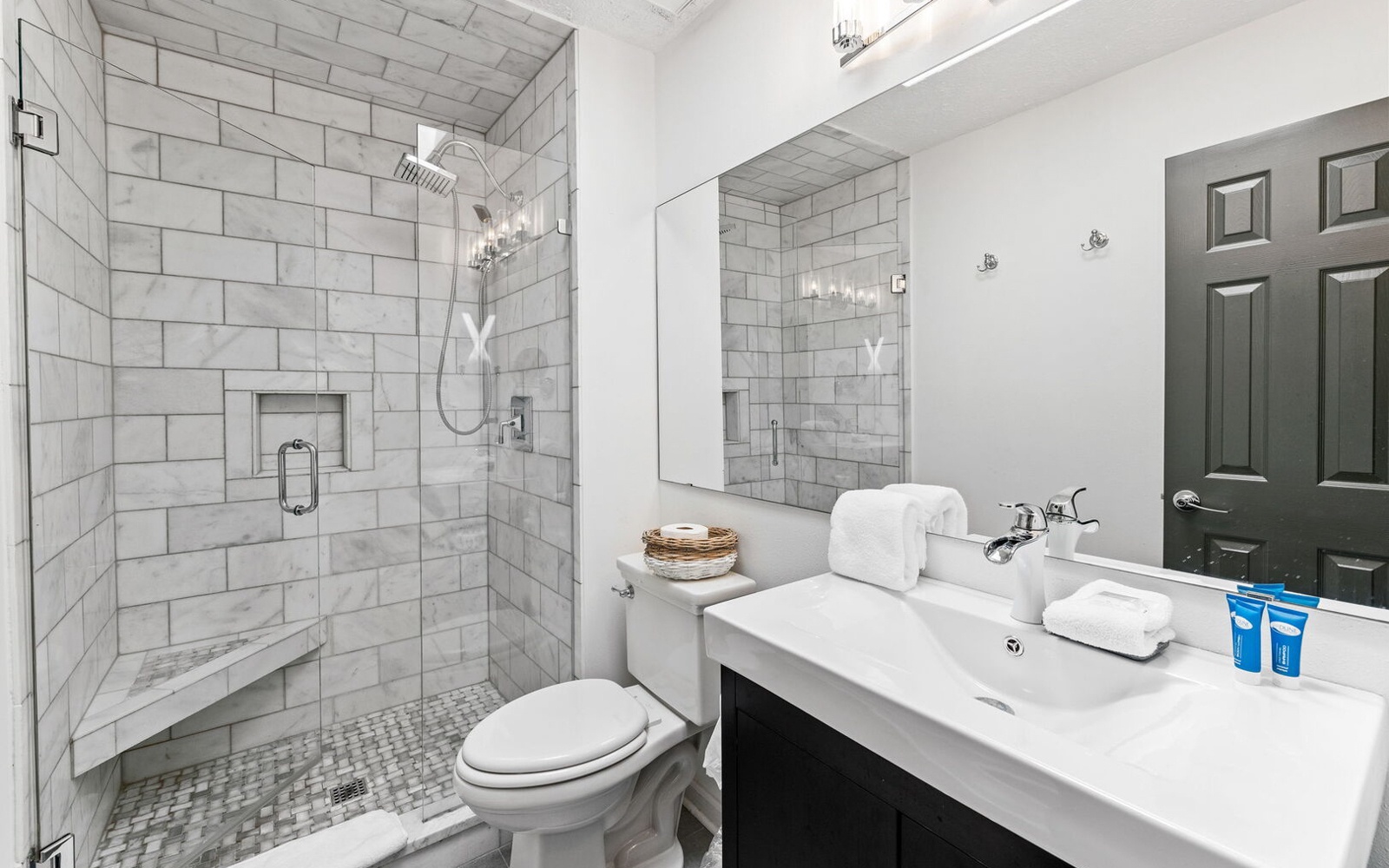 Step into your spa-like bathroom featuring elegant marble tiles, a spacious walk-in shower, and plush towels awaiting your arrival.