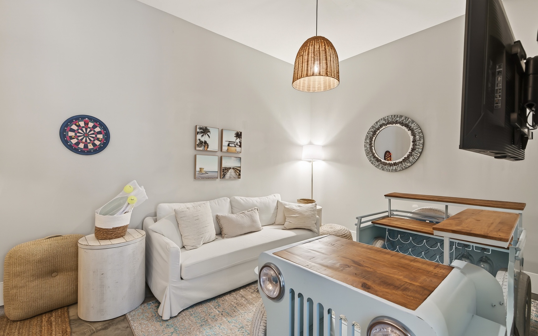 Unwind in your charming living space with coastal touches, a dartboard for entertainment, and warm lighting perfect for relaxing evenings.