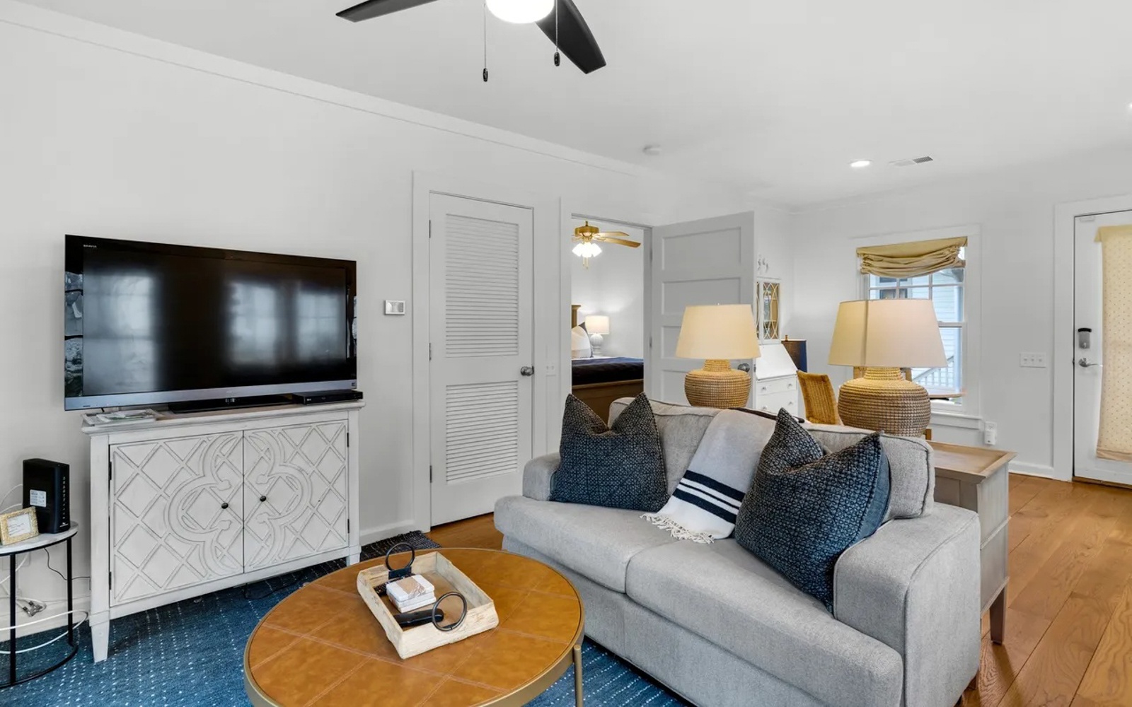 Unwind in your stylish living space featuring a cozy sofa, large TV, and warm lighting that creates the perfect atmosphere for relaxation.