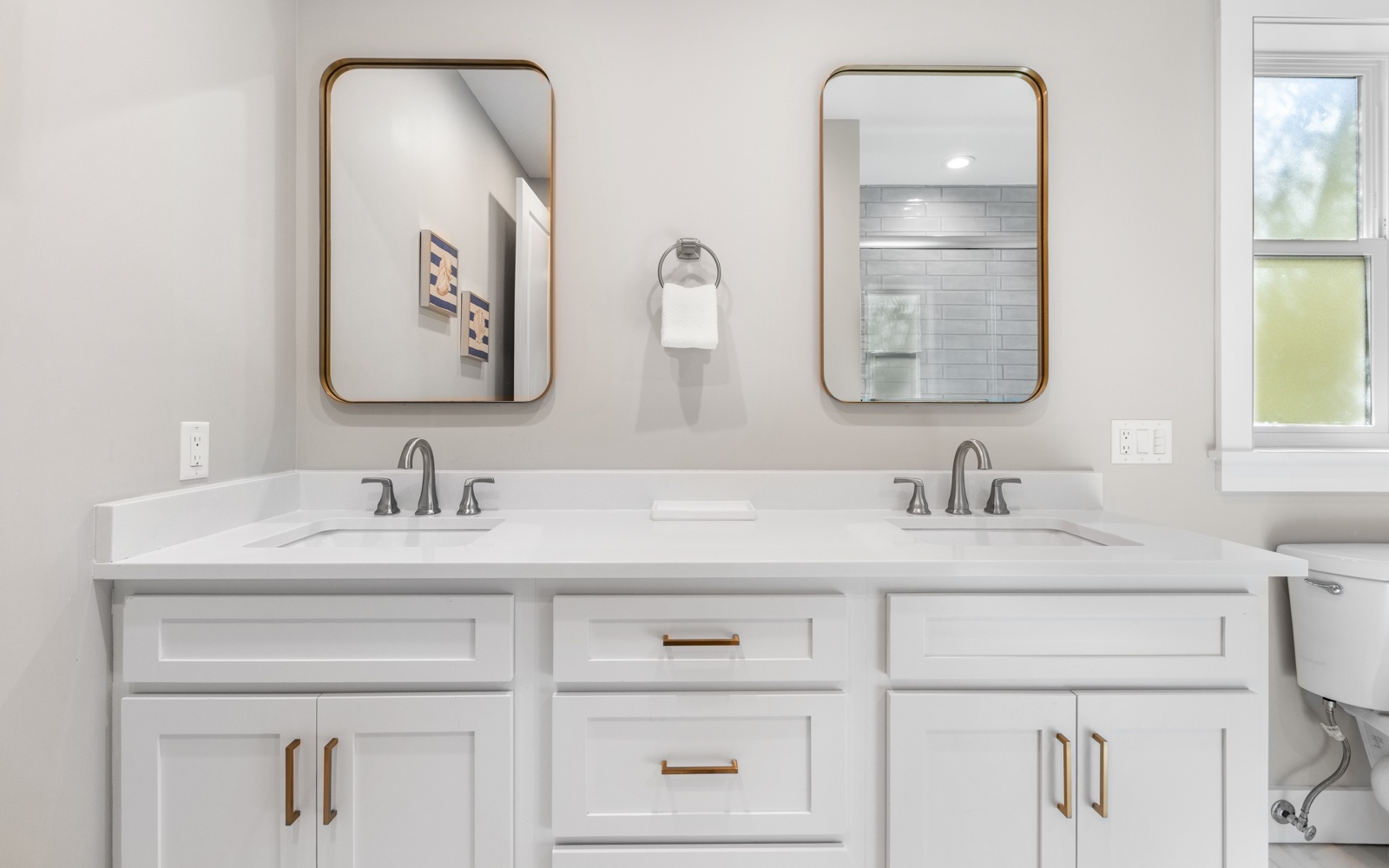 Start your mornings at this elegant double vanity with brass fixtures and spa-like finishes that make getting ready feel luxurious.