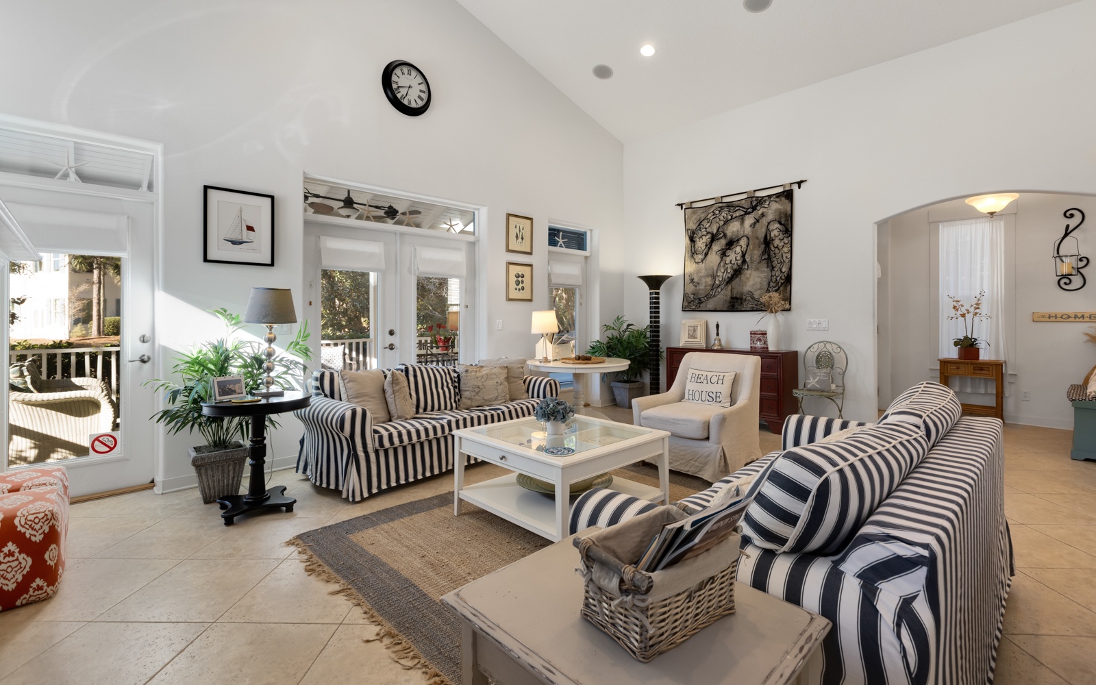 Relax in this bright, coastal-inspired living space with comfortable striped seating and charming nautical touches throughout.