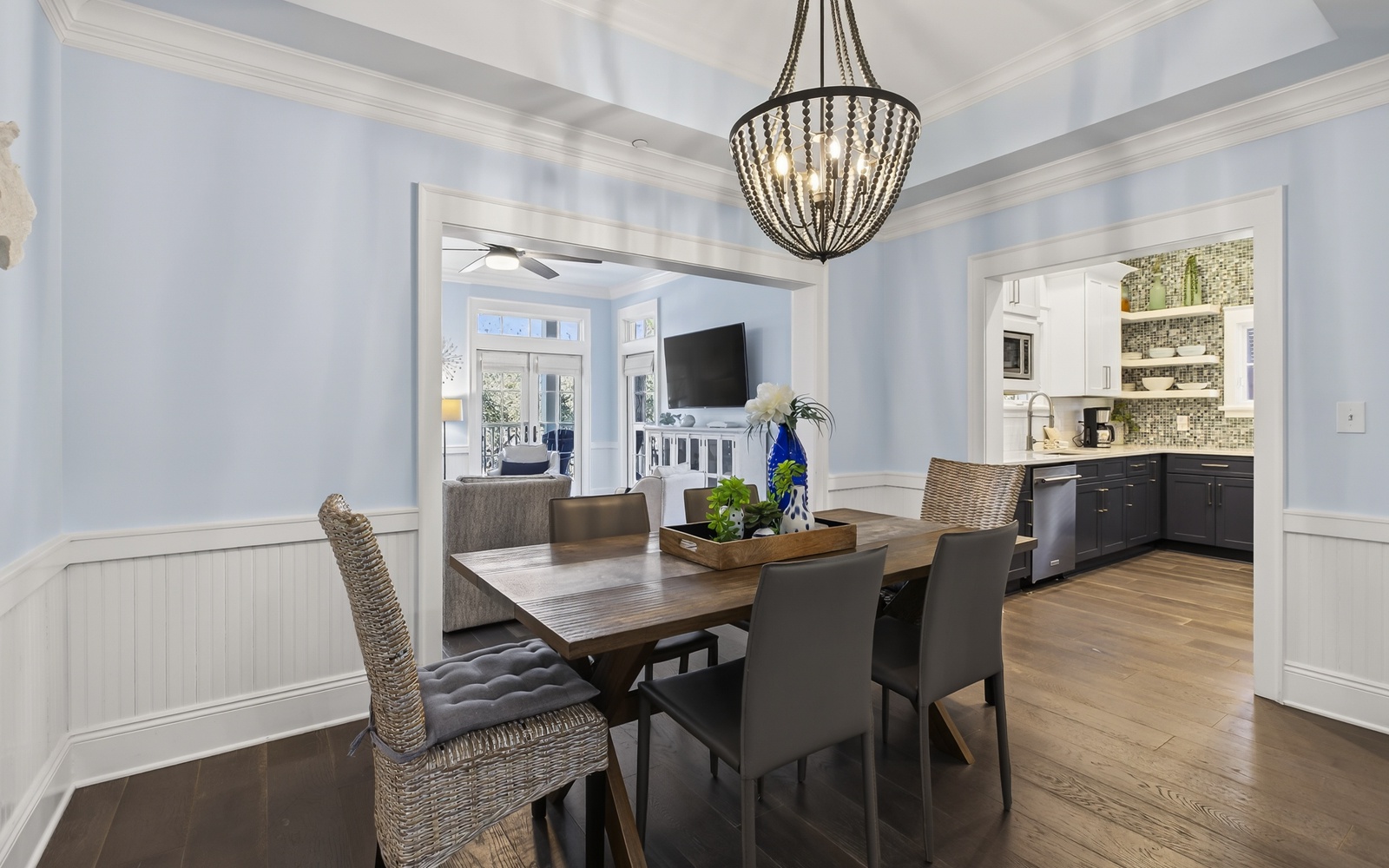 Gather around your elegant dining table beneath a stunning chandelier, with gleaming hardwood floors and an open kitchen perfect for entertaining.