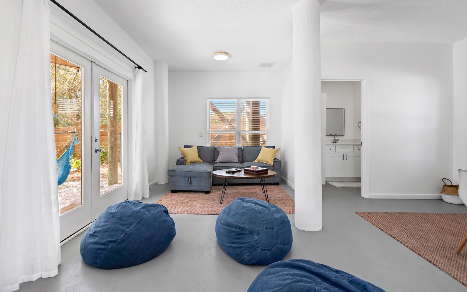 Your bright living space flows seamlessly to the outdoor patio, where cozy bean bags invite lazy afternoons and the kitchen beckons.