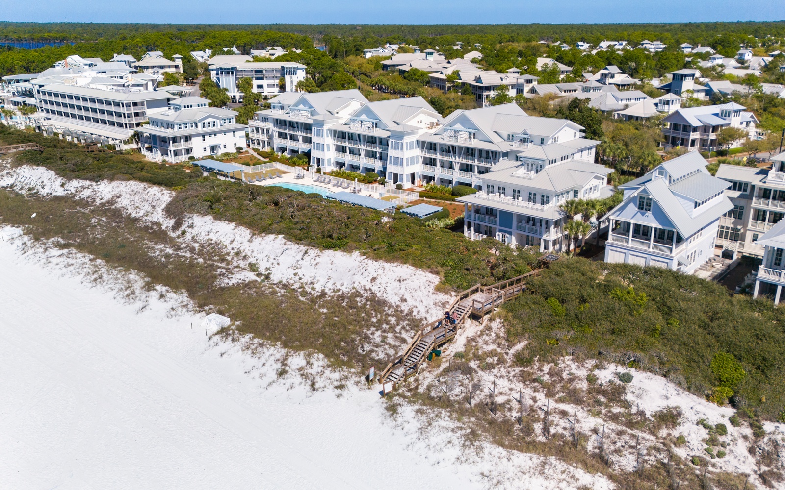 Stunning beachfront resort complex with pristine white sand beaches and elegant coastal architecture nestled among natural dunes.