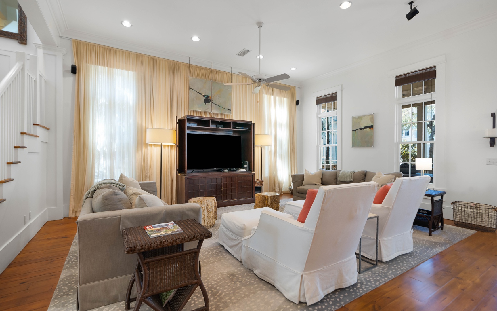 Unwind in your elegantly appointed living room with plush seating, warm hardwood floors, and natural light streaming through golden curtains.