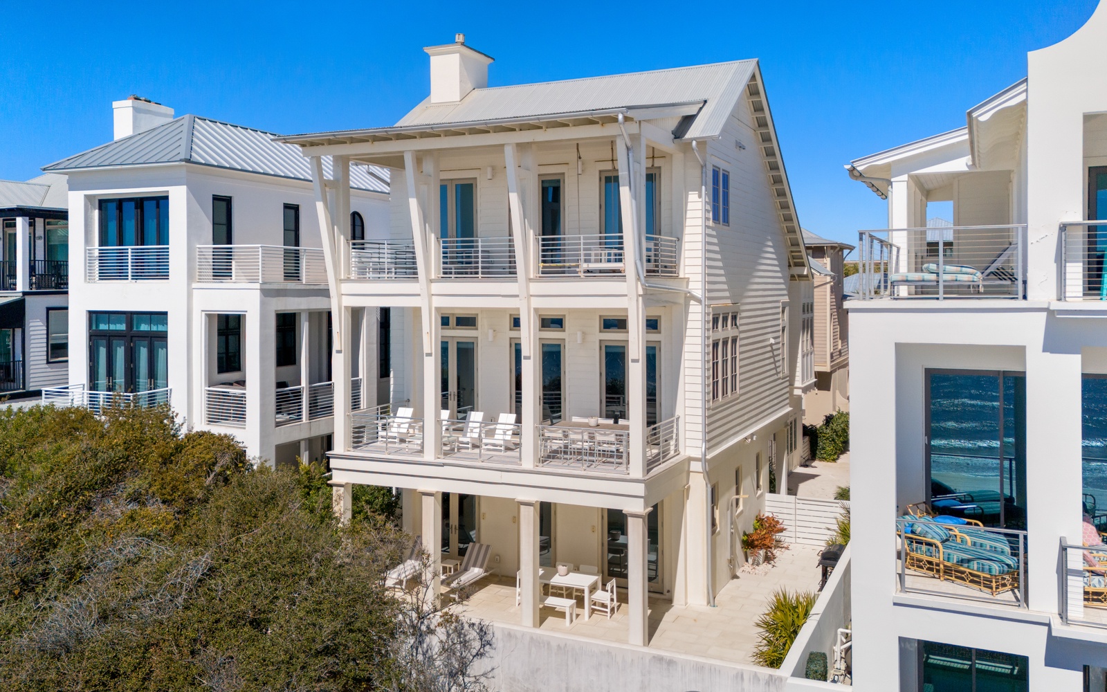 Stunning coastal architecture features multiple levels of covered porches and modern balconies in this beachside neighborhood.