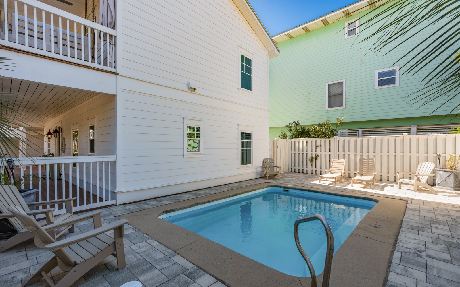 Your private pool oasis awaits between charming coastal homes, perfect for afternoon swims and sunny lounging.