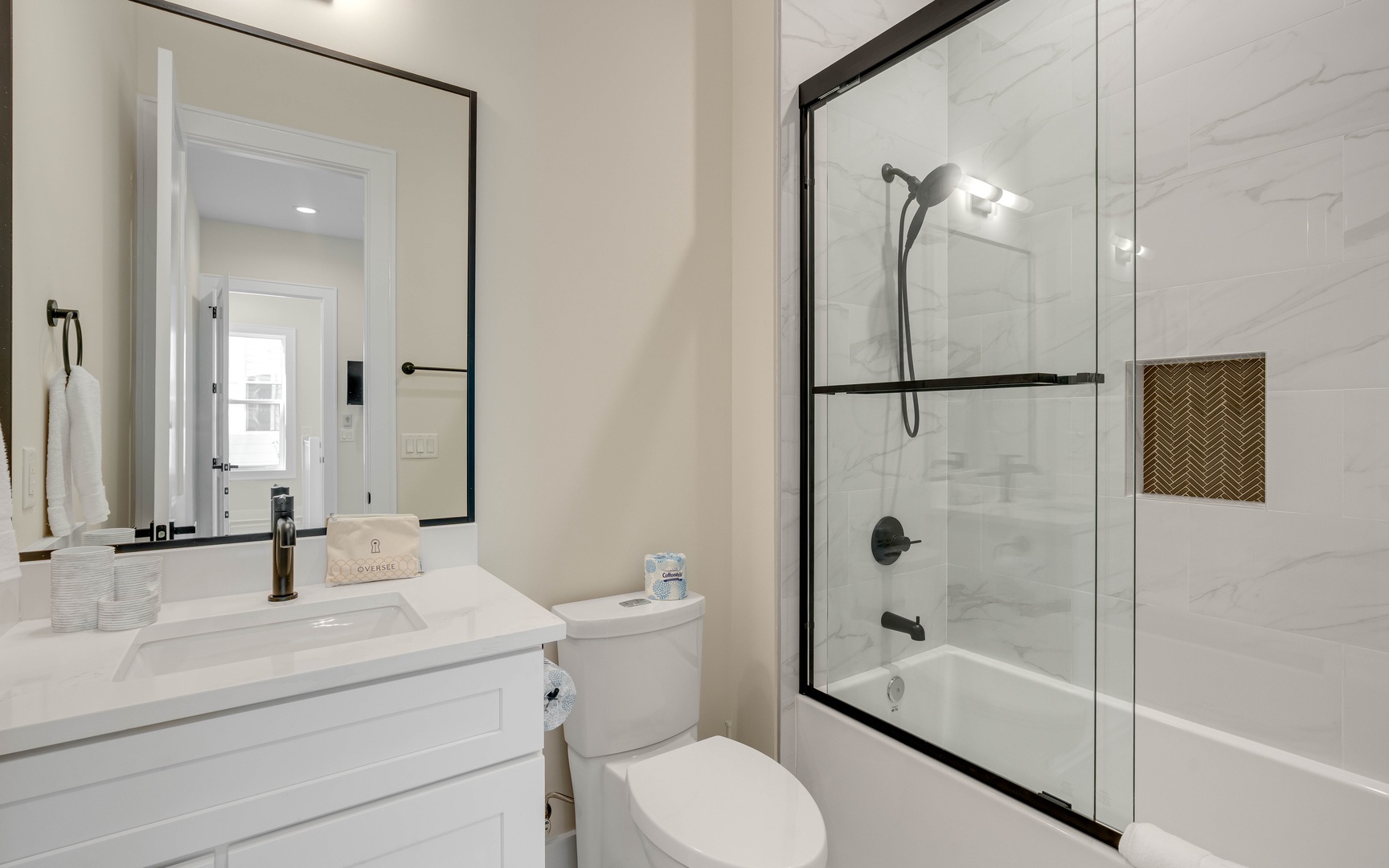 Step into your pristine bathroom featuring elegant marble-look tiles and a spacious glass-enclosed tub-shower combo for your daily refresh.